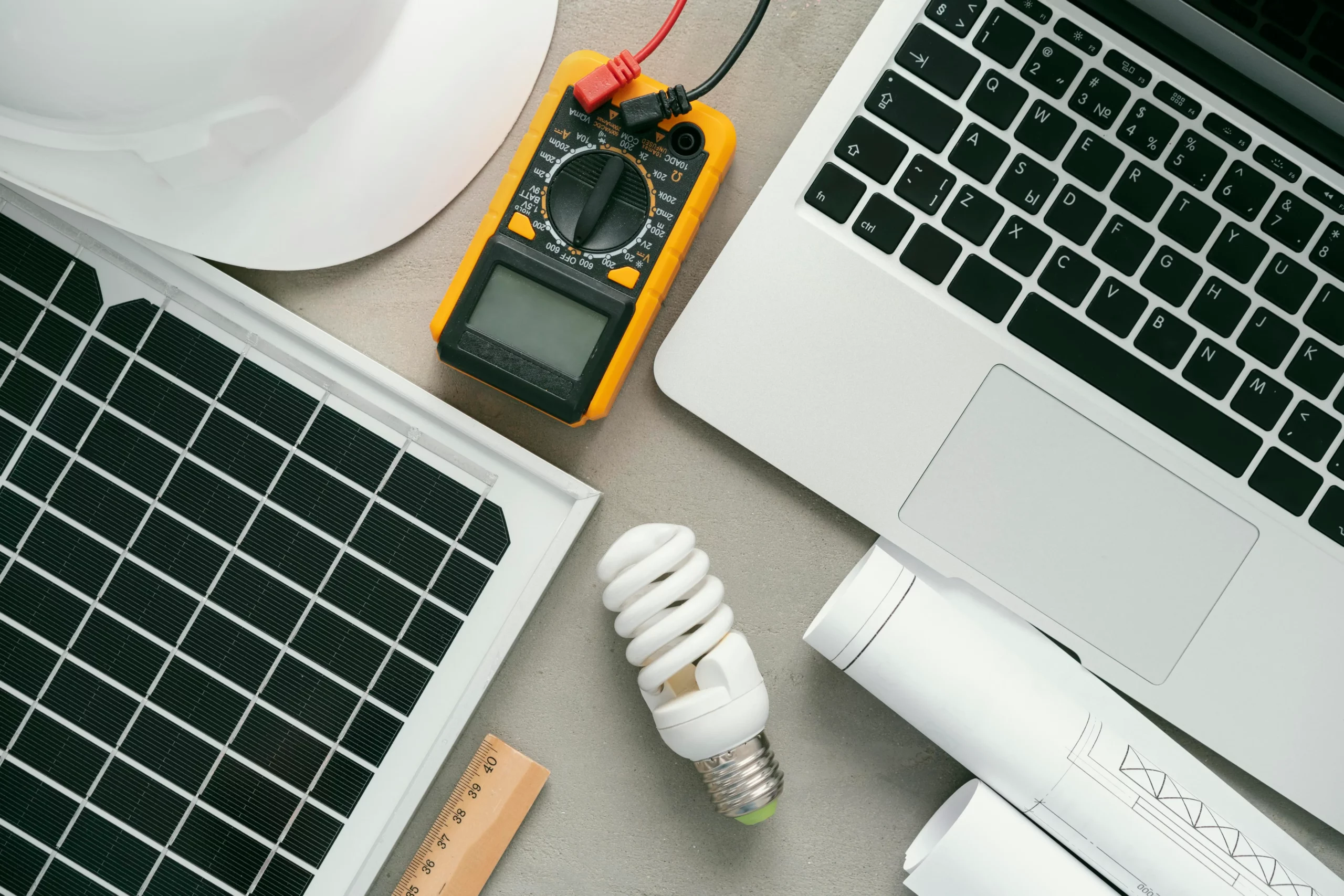 Picture with objects related to electrical engineering: computer, light bulb, ammeter, solar panel