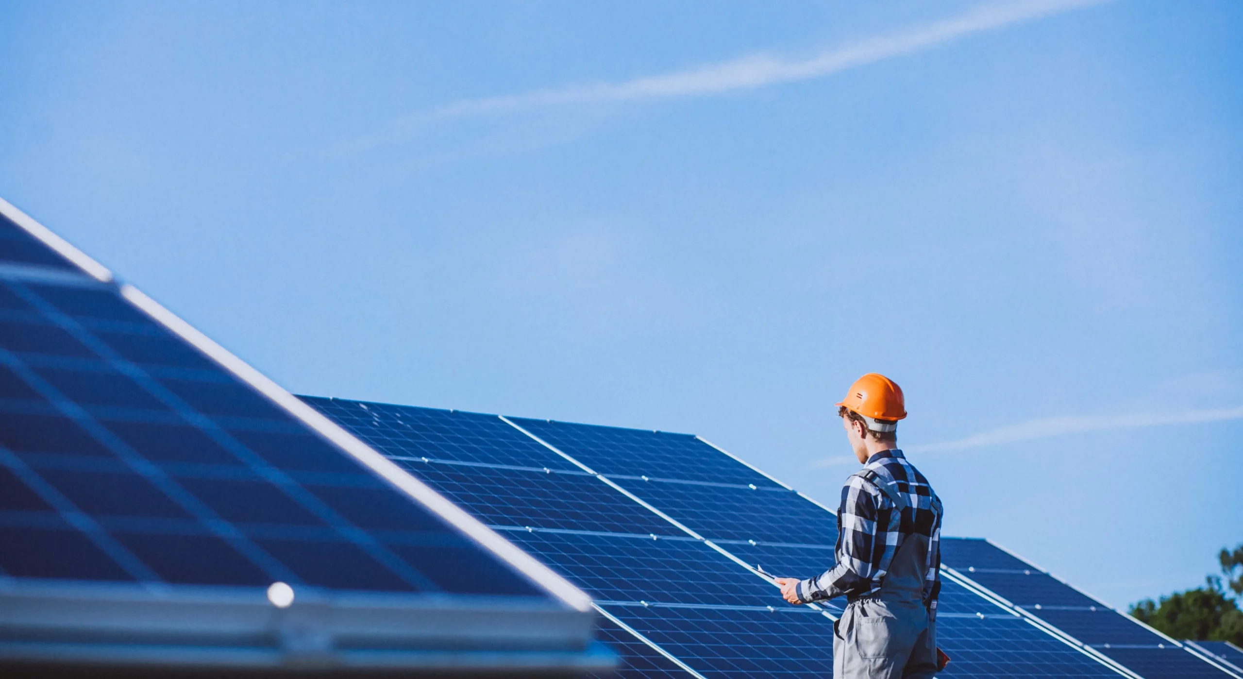 Picture of a man with a helmet looking at solar panels