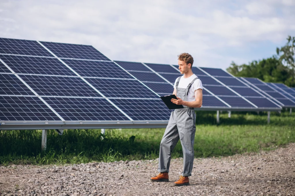 Man worker standing by solar panels