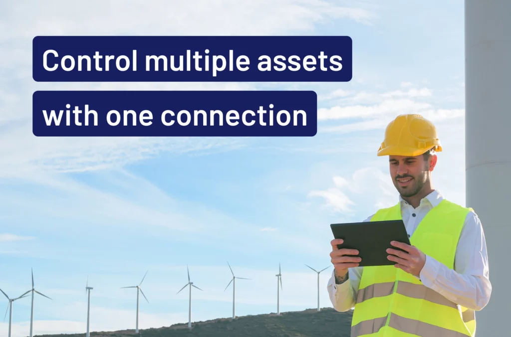 Man with an ipad checking the asset which is a wind turbine behind him